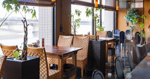a restaurant with tables and chairs and plants at Hotel SEASONS NICHINAN in Nichinan