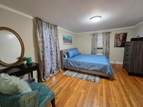 a bedroom with a bed and a mirror and a chair at 2 Bedroom Apartment on Quinsigamond Lake in Shrewsbury