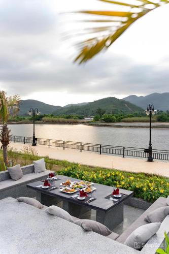 a table with food on it next to a river at Cami Riverside Resort Da Nang in Da Nang