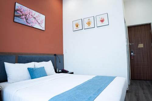 a hotel room with a bed and a door at Mango Hotel - Ha Noi Railway station in Hanoi