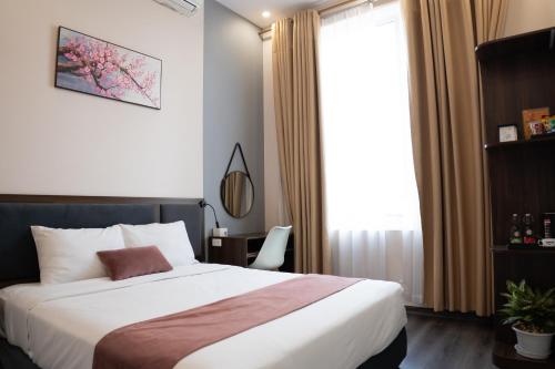 a bedroom with a large bed and a window at Mango Hotel - Ha Noi Railway station in Hanoi