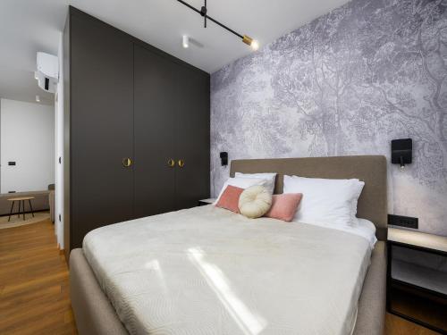 a bedroom with a large white bed with pink pillows at Room in Porec by Old Town & Waterfront in Poreč