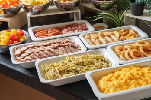 a table topped with trays of different types of food at Hotel Vista Tokyo Tsukiji in Tokyo