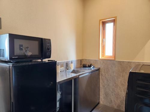 a kitchen with a tv on top of a refrigerator at KAMAKURA Beach House in Kamakura