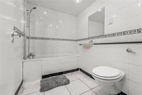 a bathroom with a toilet and a tub and a sink at Cheap modern room in Dublin