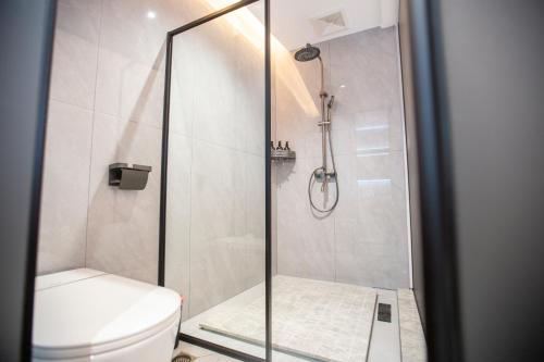 a shower stall in a bathroom with a toilet at Xingfu Farm Resort in Zhangjiajie