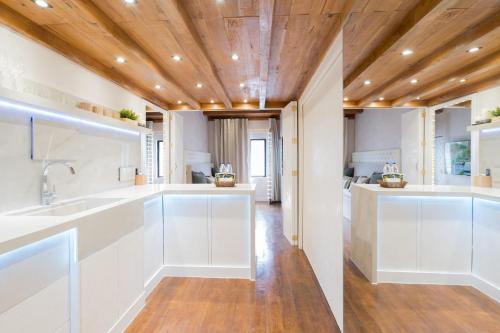 a kitchen with white cabinets and a wooden ceiling at Cozy Cabin Style 48 sqm 500MBPS in Mandaue City