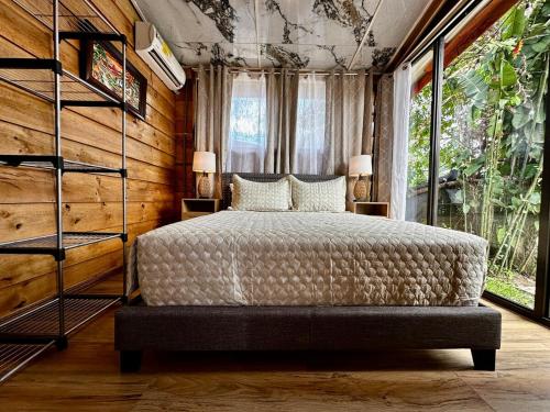 a bedroom with a bed and a large window at Tribu Bungalow 1 Modern and Centrally Located in Fortuna