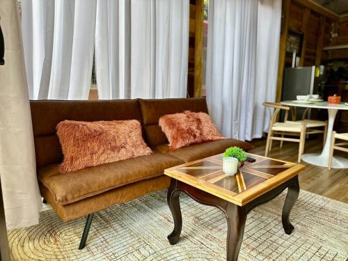 a living room with a brown couch and a coffee table at Tribu Bungalow 1 Modern and Centrally Located in Fortuna