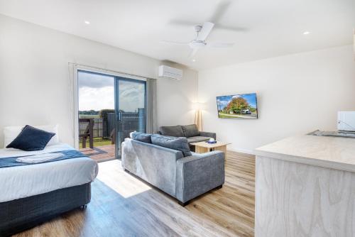 a living room with a bed and a couch at Inverloch Motel in Inverloch