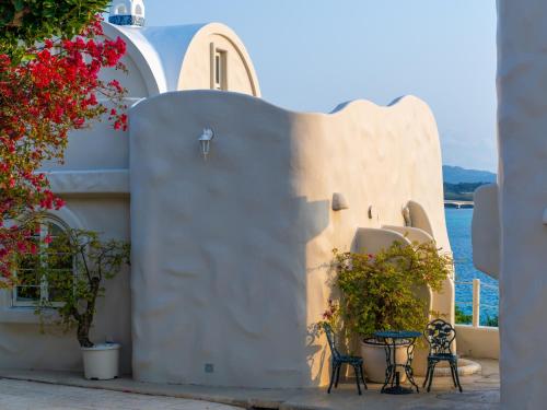 a white building with tables and chairs and flowers at Yuki Suite Kourijima in Nakijin