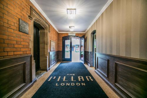 a hallway with a sign that reads the miller london at The Pillar Hotel in London