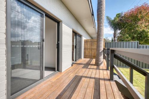 a wooden deck with sliding glass doors on a house at Inverloch Motel in Inverloch
