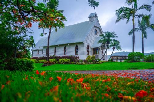 a white church with palm trees and flowers in front at Beachfront Hamilton Island in Hamilton Island