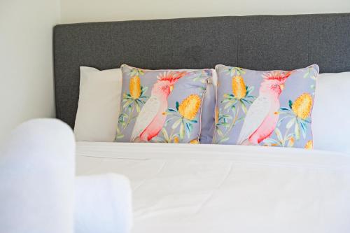 a bed with two pillows with flamingos on it at 5BR Peaceful Oasis with Wifi Garage in Hornsby