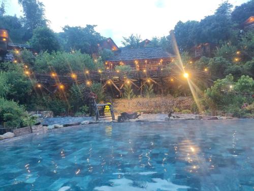 a large swimming pool in front of a house at Cầu Treo Homestay in Cham Ta Lao