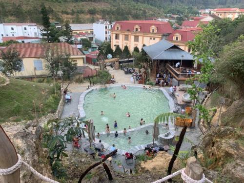 a group of people in a pool at a resort at Cầu Treo Homestay in Cham Ta Lao