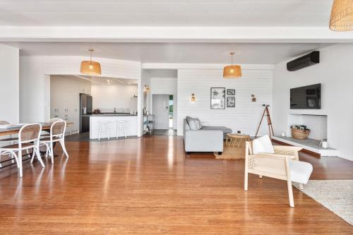 an open living room with a table and chairs at Coastal Vista - Ngunguru Holiday Home in Ngunguru
