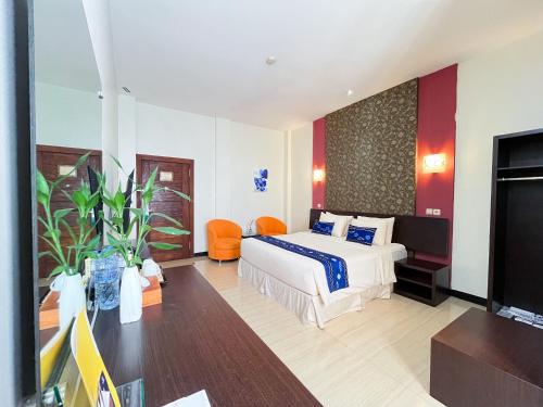 ein Hotelzimmer mit einem Bett und einem Flachbildfernseher in der Unterkunft Hotel Roditha Banjarbaru in Banjarbaru