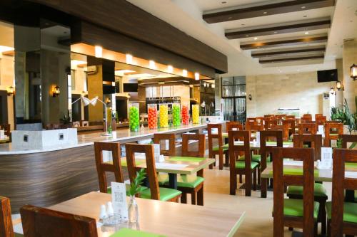 ein Restaurant mit Holztischen und Holzstühlen in der Unterkunft Hotel Roditha Banjarbaru in Banjarbaru