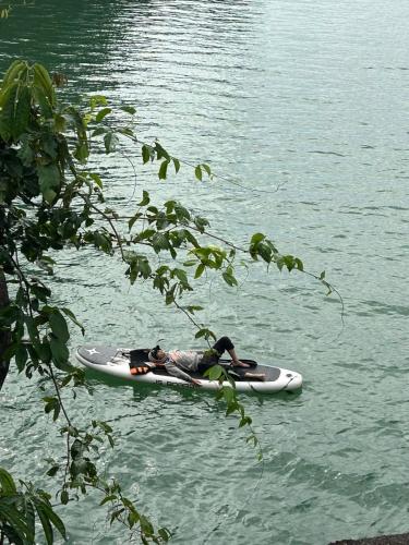 a person laying on a kayak in the water at An Trú Homestay in Tang Klang
