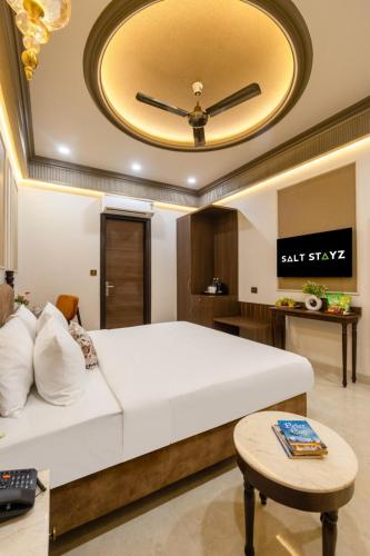 a bedroom with a large bed with a ceiling at Saltstayz Autograph - Connaught Place in New Delhi