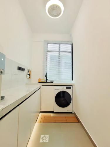 a white kitchen with a washing machine in the middle at Kingfisher Sandakan in Sandakan