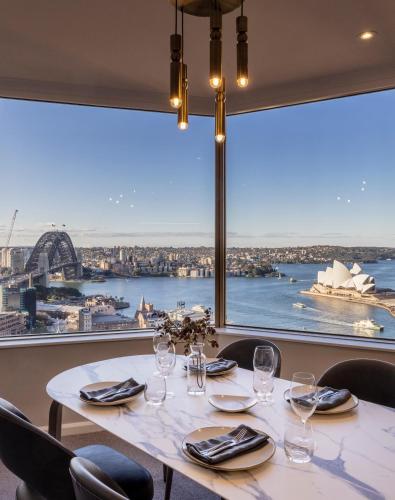 a table at a restaurant with a view of the sydney harbour at The Sebel Quay West Suites Sydney in Sydney