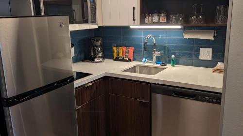 a kitchen with a sink and a refrigerator at Staybridge Suites Bismarck by IHG in Bismarck