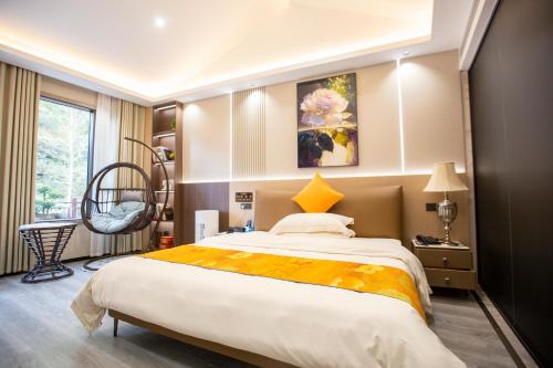 a bedroom with a large bed and a chair at Xingfu Farm Resort in Zhangjiajie