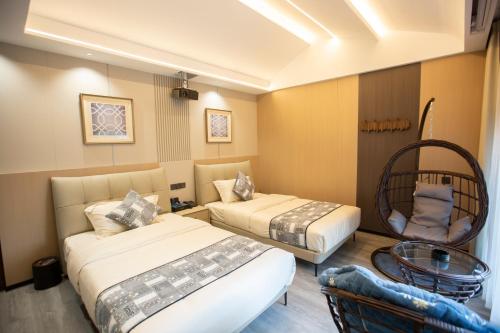 a hotel room with two beds and a table at Xingfu Farm Resort in Zhangjiajie