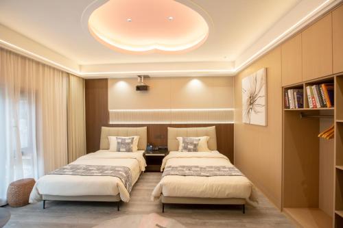 two beds in a room with a large ceiling at Xingfu Farm Resort in Zhangjiajie