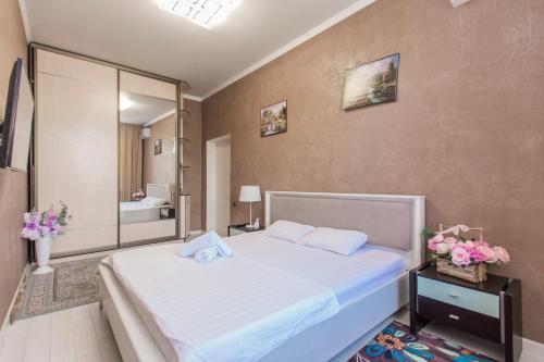 a bedroom with a large white bed and a mirror at Двухкомнатная евро двушка в самом центре Алматы, 10 минут ходьбы до Арбата #23 in Almaty