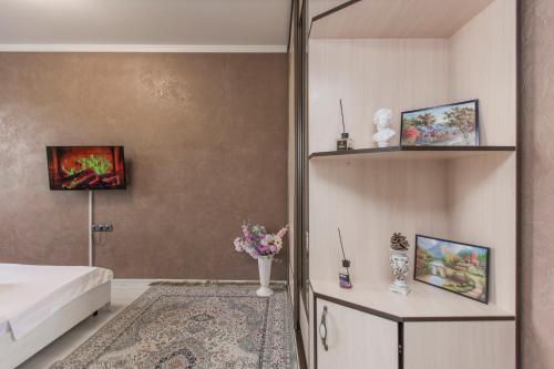 a bedroom with a bed and a shelf with paintings at Двухкомнатная евро двушка в самом центре Алматы, 10 минут ходьбы до Арбата #23 in Almaty