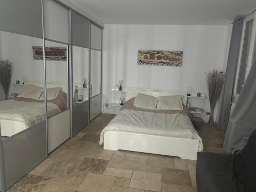une chambre avec deux lits et un miroir dans l'établissement Bas de villa, à La Seyne-sur-Mer