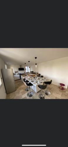 Cette grande chambre comprend une grande table et des chaises. dans l'établissement Bas de villa, à La Seyne-sur-Mer