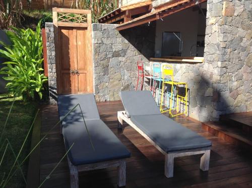 a patio with two benches and a table and chairs at La Villa Paille en Queue in Saint-Gilles les Bains