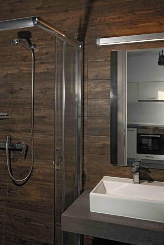 a bathroom with a sink and a shower and a mirror at Corali luxury villas in Ierissos