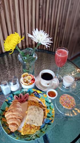 a glass table with a plate of bread and a drink at Hotel Boutique Stay La 10 in Medellín