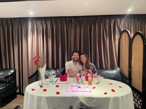 a man and woman sitting at a table with a love sign at Scarlet Pearl Cruises - Wonder On Lan Ha Bay in Ha Long