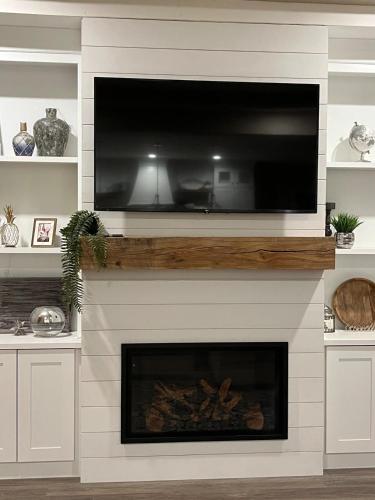a tv over a fireplace with a television above it at Lakeside Paradise! in Brule