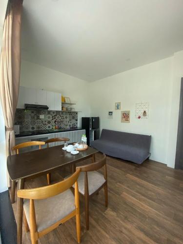 a living room with a table and chairs and a couch at Alina Retreat in Hiếu Nhơn