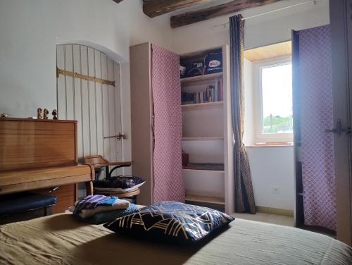 a bedroom with a bed and a desk and a piano at Le paradis des chats bercéen chez Stéphanie près circuit du Mans, animaux acceptés in Marigné-Laillé