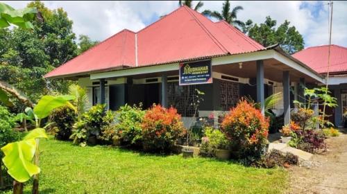 a house with a red roof and some bushes at Homestay Mudhahar Panampuang in Baso