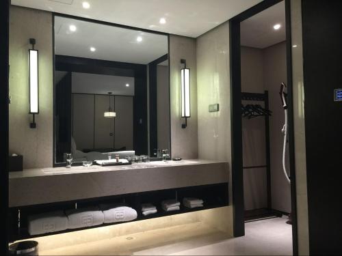 a bathroom with a sink and a large mirror at Eastern House Xi'an in Xi'an