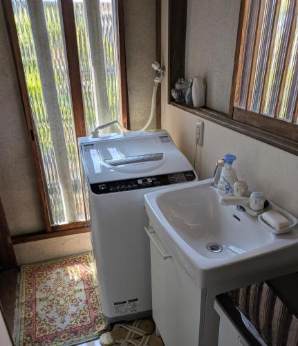 a small kitchen with a sink and a washing machine at Tsubakiso in Nara