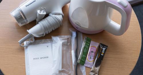 a table with a hairdryer a hair dryer and a hair brush at Hotel SEASONS NICHINAN in Nichinan