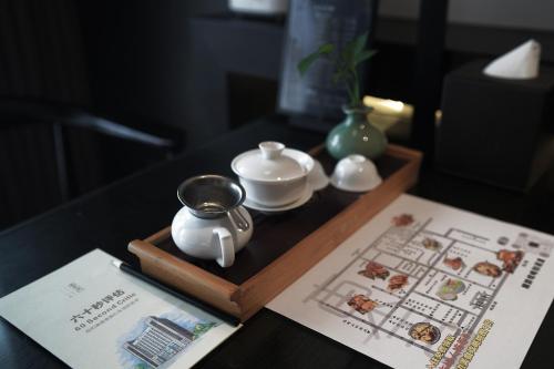 a table with a tea set on a wooden tray at Eastern House Xi'an in Xi'an