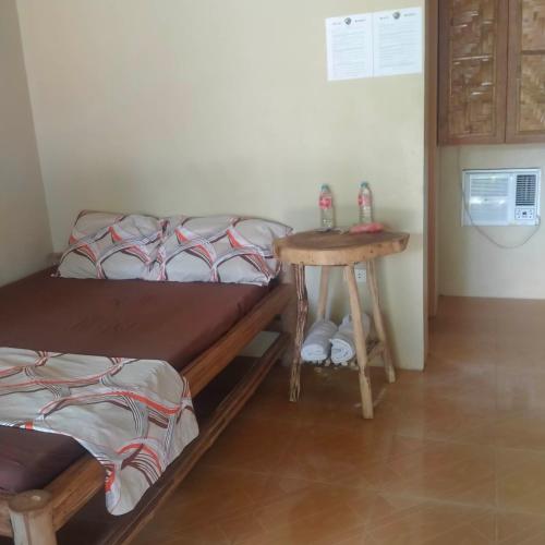 a bedroom with a bed and a small table at Palaboy Skatecamp Native House Beach Resort in Daanbantayan