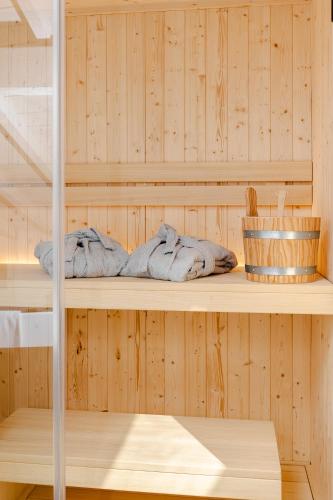 a sauna with wooden walls and shelves with towels at VicoloSuite - Lago di Garda in Torri del Benaco